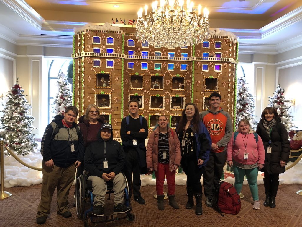 Students in front a gingerbread house.